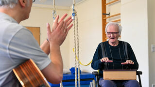 Music therapist plays the guitar for a client
