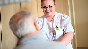 Carer cares for patients at the hospital bed.