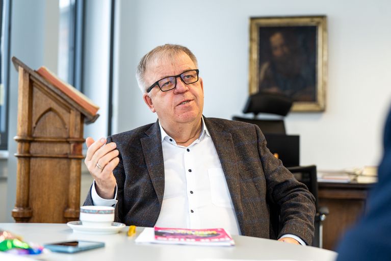 Pastor Uhlrich Pohl erzählt seinem Interviewpartner etwas.