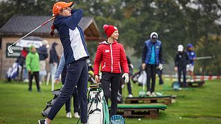 Abschlag einer Golfspielerin auf dem Green
