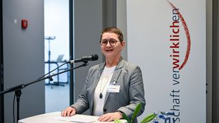 Ulrike Fahlberg spricht ins Mikrophon am Rednerpult.