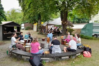 Eine Trommelgruppe hat sich versammelt und spielt auf seinen Instrumenten.