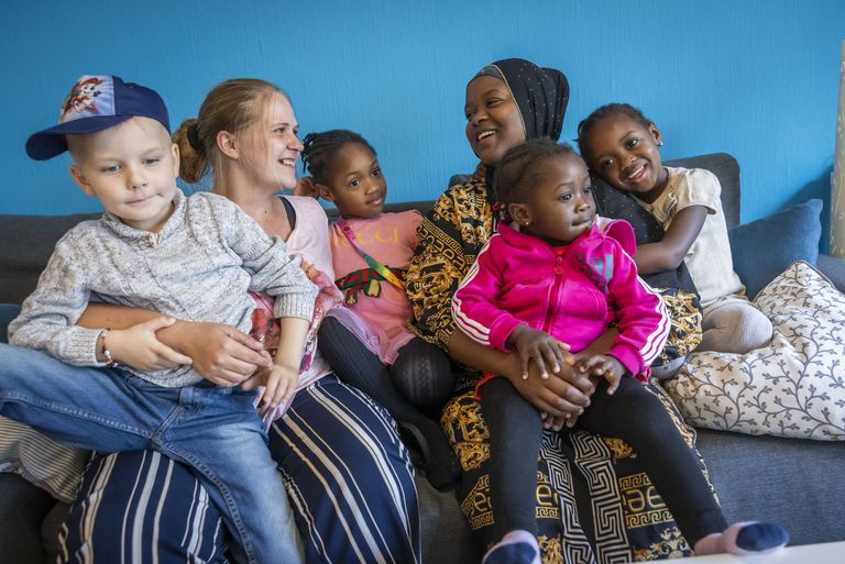 Zwei Frauen und ihre Kinder lachen gemeinsam.