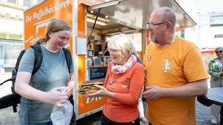 Lelaina Otto is given waffles at a stand