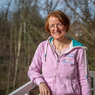 Stefanie Feldmann steht auf einem Balkon. 