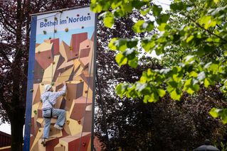 Ein junger Mann klettert die Kletterwand von Bethel im Norden hoch