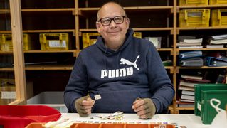 Mann sortiert Briefmarken 