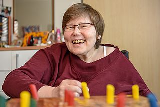 Eine Frau lacht in die Kamera
