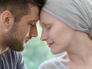 Mann und Frau berühren sich liebevoll mit den Köpfen.