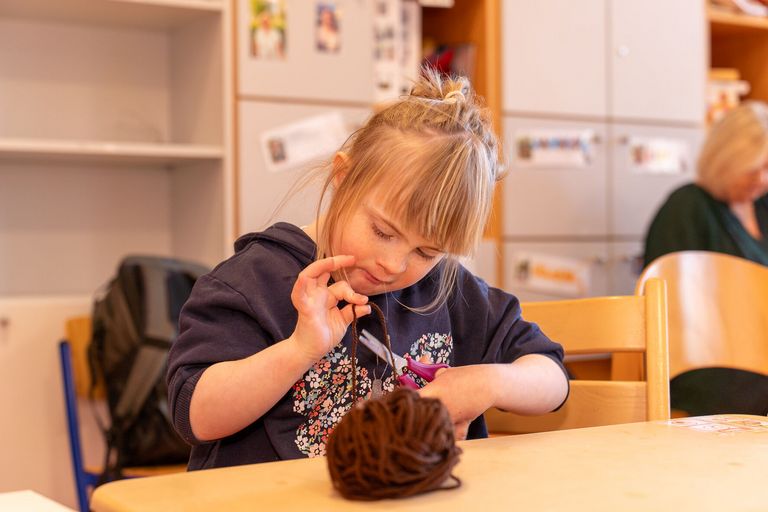 Ein Mädchen bastelt eine Weihnachtskarte.