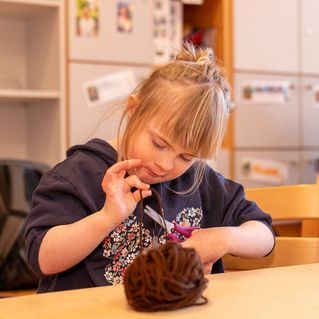 Ein Mädchen bastelt eine Weihnachtskarte.