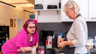 Marion Thielecke steht in der Küche und unterhält sich mit Antje Gärtner.