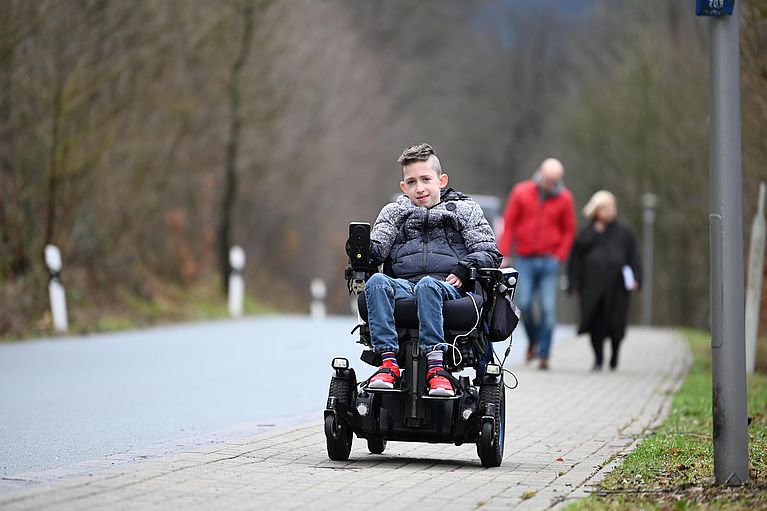 Junge aus Kinderhospiz in elektrischem Rollstuhl