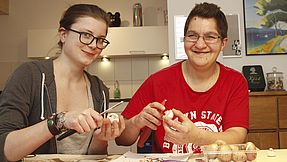 Eine Pflegerin kocht zusammen mit einem Patienten.