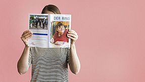 Person hält Ring-Magazin hoch