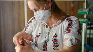 Mother holding baby in her arms.