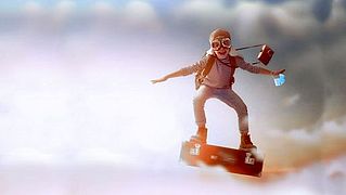 Logo der Ferienspiele: Kind auf fliegendem Koffer