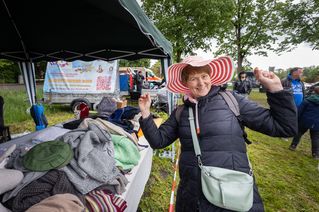 Eine Frau probiert einen Hut auf.