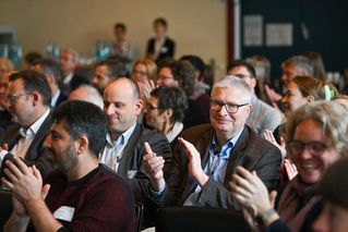 Menschen im Publikum applaudieren