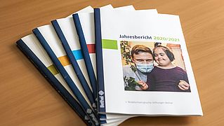 Jahresberichte der vergangenen Jahre gefächert ausgebreitet.