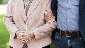 Man supports an elderly woman