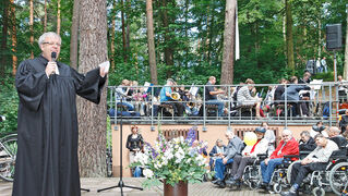 Pastor Pohl in der Waldkirche Lobetal vor Publikum