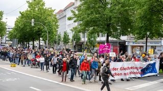 Der Demonstrationszug bewegt sich auf einer Straße voran.
