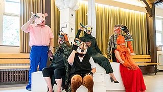 Schauspieler in Tierkostümen bei den Proben.