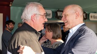 Arminia-Präsident Rainer Schütte begrüßt Fan Rainer Wollenburg beim Grillen unter der Westtribüne.