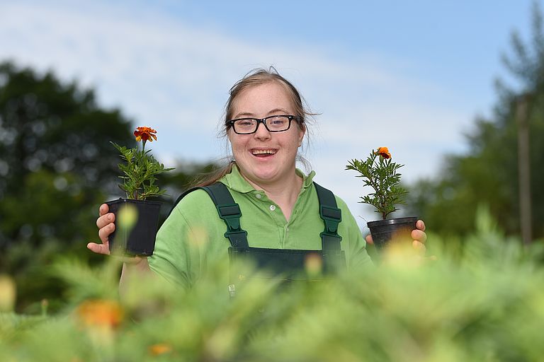 Frau lacht zwischen Sonnenblumen