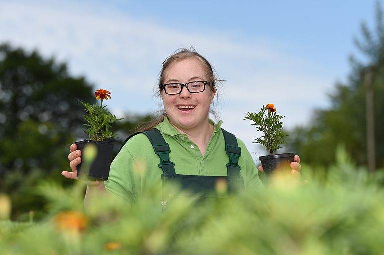 Frau lacht zwischen Sonnenblumen