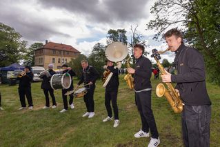 Ein Band spielt Saxophon, Trommel und Tuba auf dem Festgelände