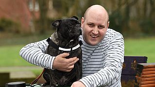 Mann mit Hund im Arm