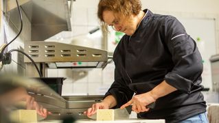 Sonja Schüler schneidet in der Küche Feta-Käse in Scheiben.