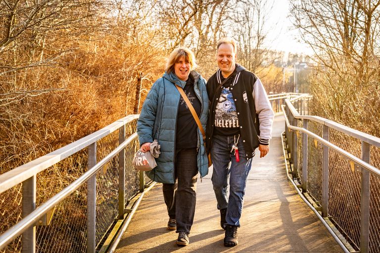 Carsten Linn und Julia Dreyer gehen auf einer Brücke durch die Natur