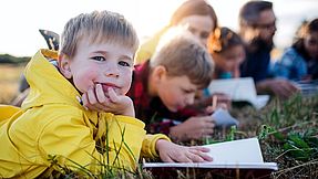 Kinder lernen im Gras