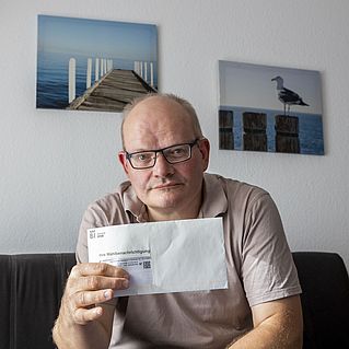 Oliver Krop hält seine Wahlbescheinigung in den Händen.