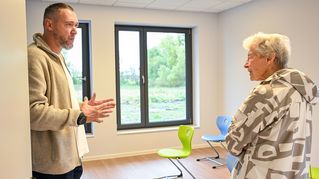 Dzianis Maksimovich zeigt Ute Huneke die Klassenräume