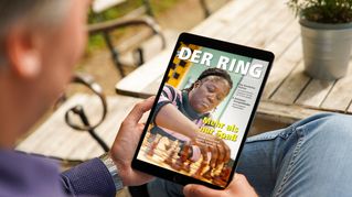 Eine Person hält ein Tablet mit der digitalen Version von DER RING in den Händen