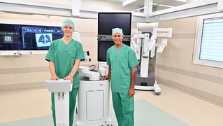Zwei Ärzte stehen mit moderner Technik im OP.