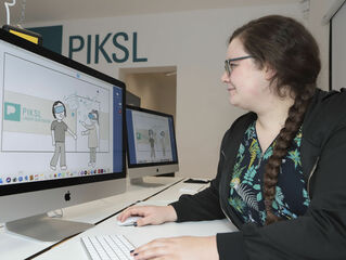 Ein Frau bearbeitet an einem Computer eine grafik.