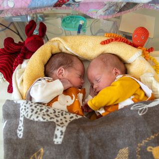 Frida und Leon liegen aneinander gekuschelt in ihrem Bett.