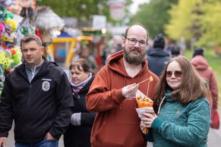 Ein Paar teilt sich eine Portion Schmalzkuchen auf dem Gelände