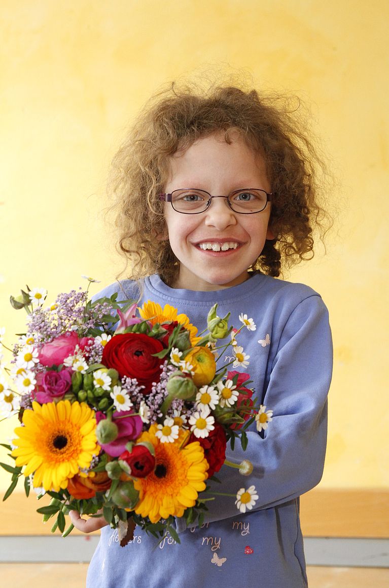 Mädchen aus Mamre-Patmos-Schule mit Blumen 