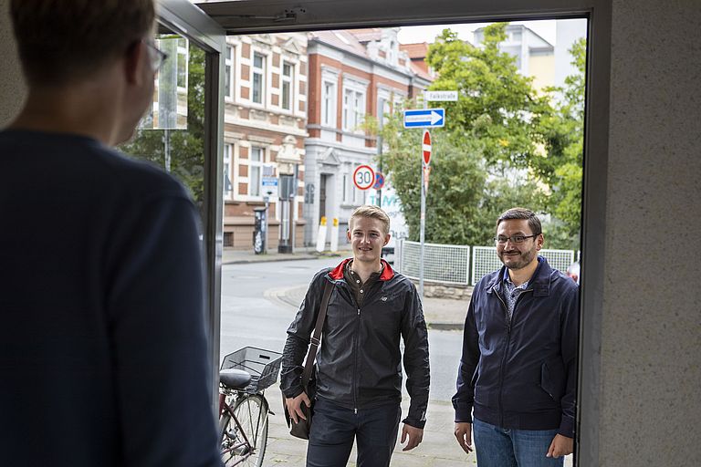 Leonhard Wohlfahrt und Muzaffer Arslan stehen vor der Haustür eines Klienten. 
