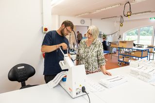 Patrick Engel und Christin Teske stehen an einer Maschine 