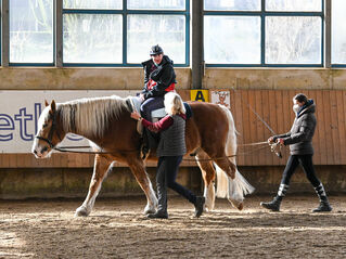 Junge reitet bei Reittherapie