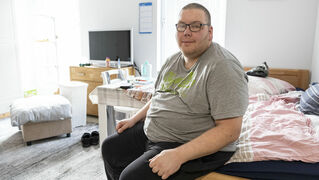 Torsten Seligmann sits on his bed.