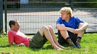 Jonah Lochmüller sitzt zusammen mit einem Klient im Garten.