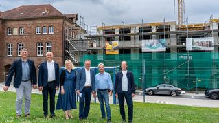 Diakon Wolfgang Roos-Pfeiffer von der Direktion Sarepta/Nazareth, Bethels stellvertretender Vorstandsvorsitzender Pastor Dr. Bartolt Haase, die Bethel.regional-Geschäftsführer Sandra Waters und Stefan Helling-Voß, Rolf Wacker, Leiter Immobilien Bethel.regional, und Architekt Sven Grüne stehen vor der Baustelle.